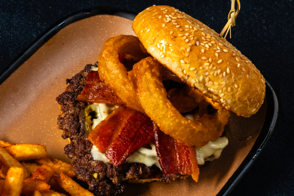picture of a burger with onion rings and bacon